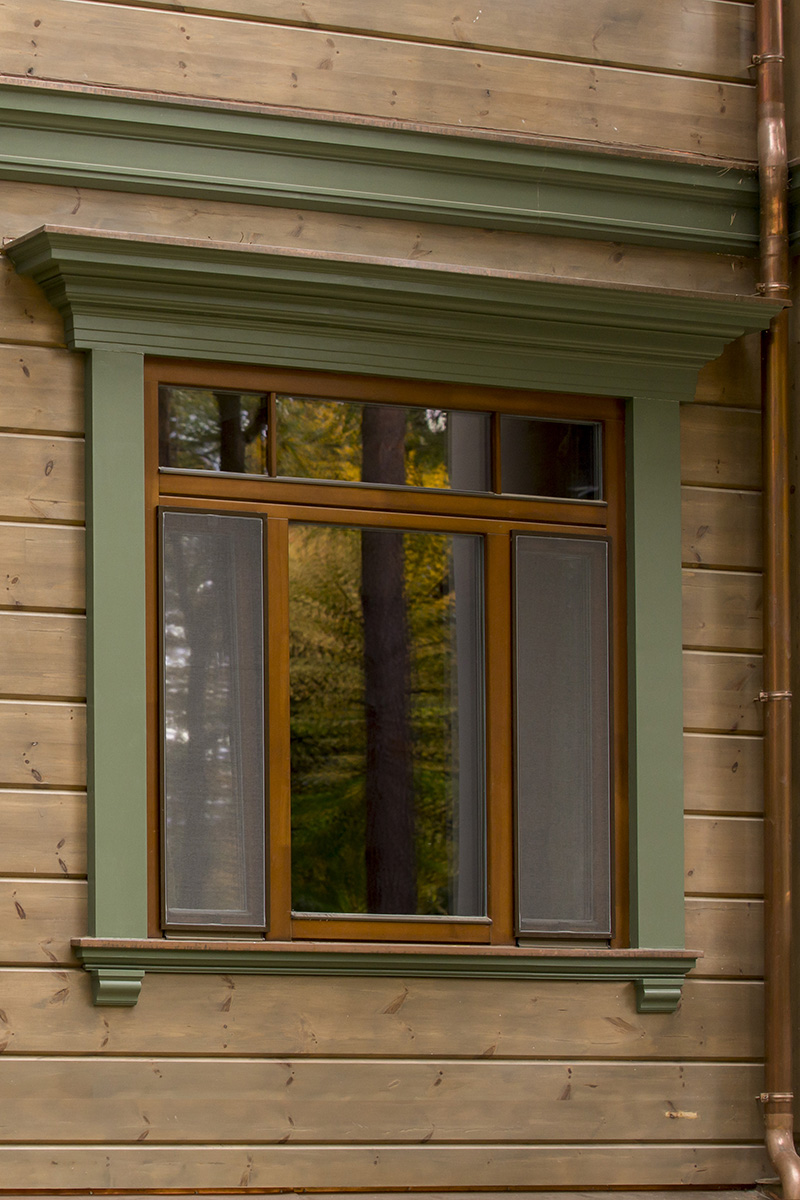 Timber house window with facade cornice and bracket